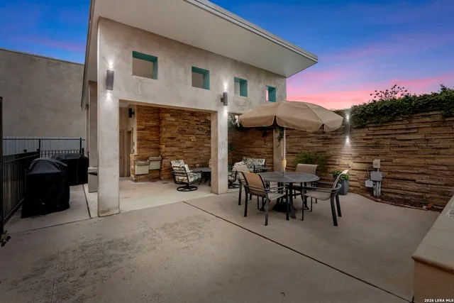 a view of a patio with table and chairs under an umbrella