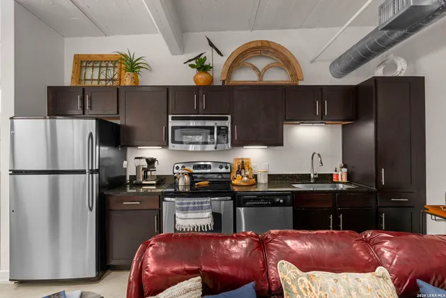 a kitchen with granite countertop a sink and a stove