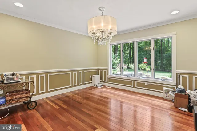 a view of a room with wooden floor fan and windows