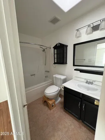 a bathroom with a toilet a sink a mirror a bathtub and shower