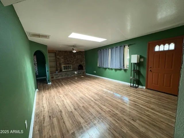 an empty room with wooden floor and a window