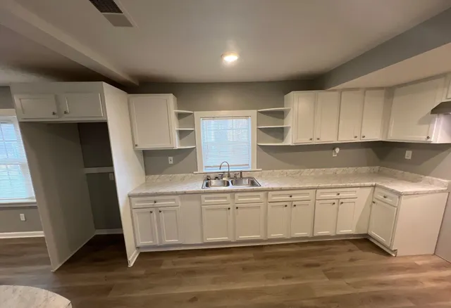 a kitchen with granite countertop a sink stove and cabinets