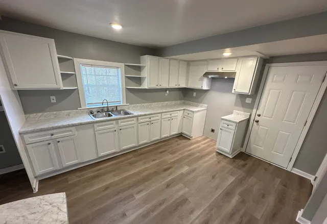 a kitchen with a sink cabinets and wooden floor