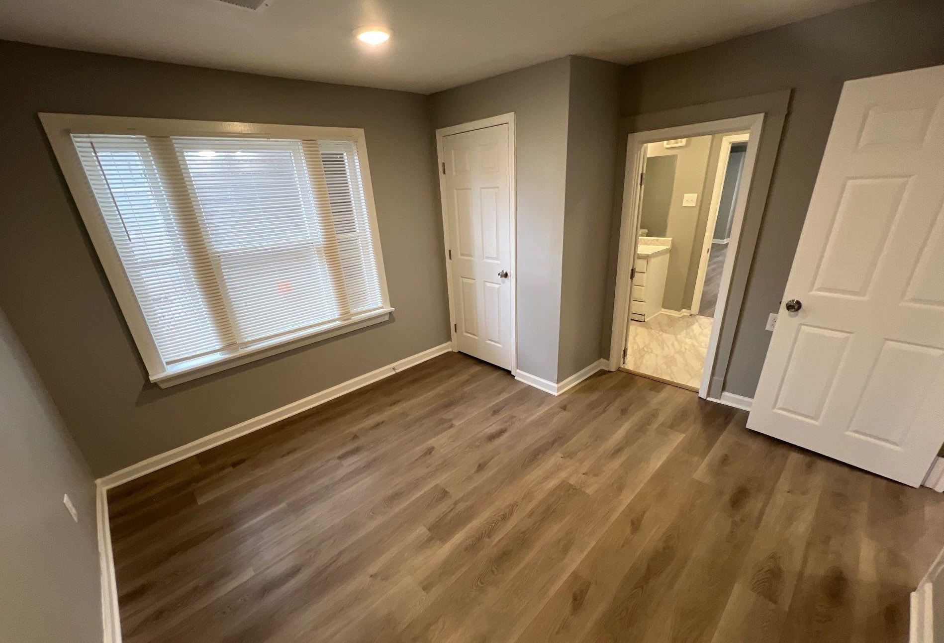 2974 Waverly Avenue Memphis, TN 38111 - Photo 9 of 13 an empty room with wooden floor and windows