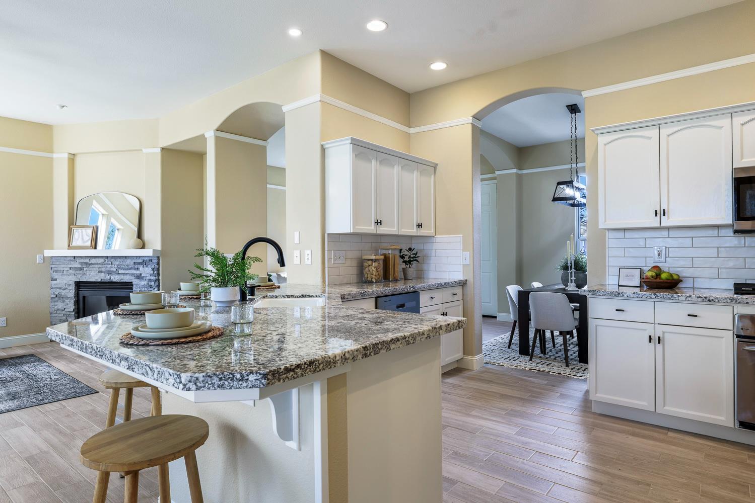 2735 Swift Avenue Clovis, CA 93611 - Photo 11 of 30 a kitchen with kitchen island granite countertop a stove a sink a refrigerator dining table and chairs