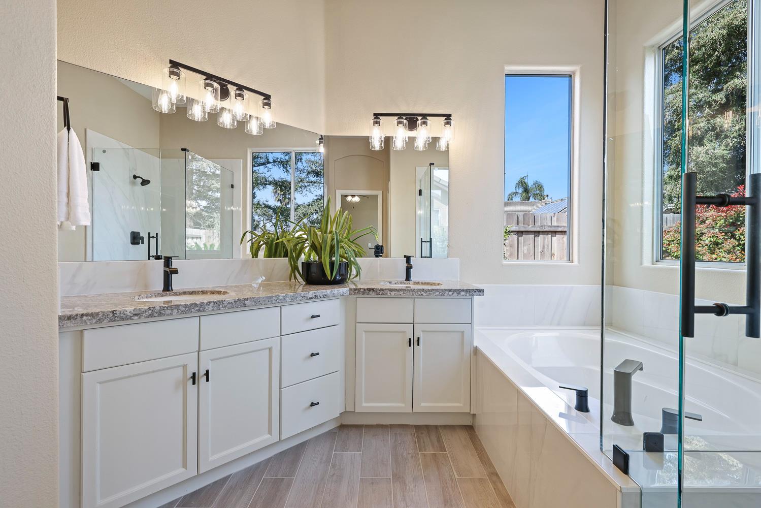 2735 Swift Avenue Clovis, CA 93611 - Photo 19 of 30 a bathroom with a granite countertop bathtub a sink and a large mirror