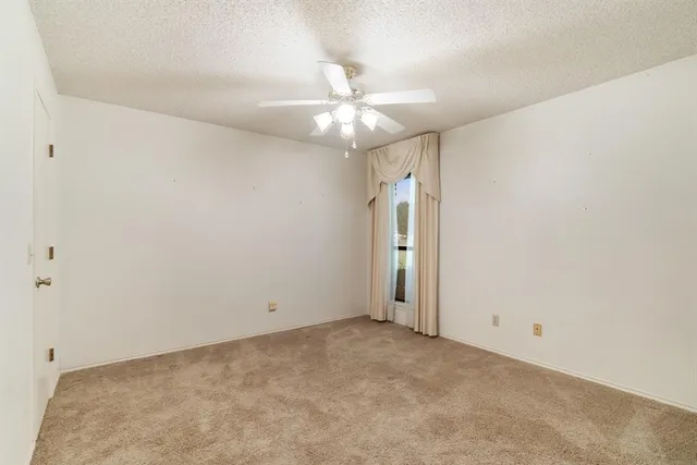 an empty room with closet and a ceiling fan