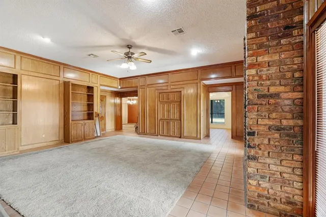 a view of a hallway with brick walls and a chandelier
