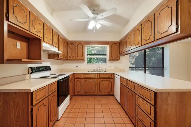 a kitchen with stainless steel appliances granite countertop a sink and dishwasher a stove with wooden cabinets