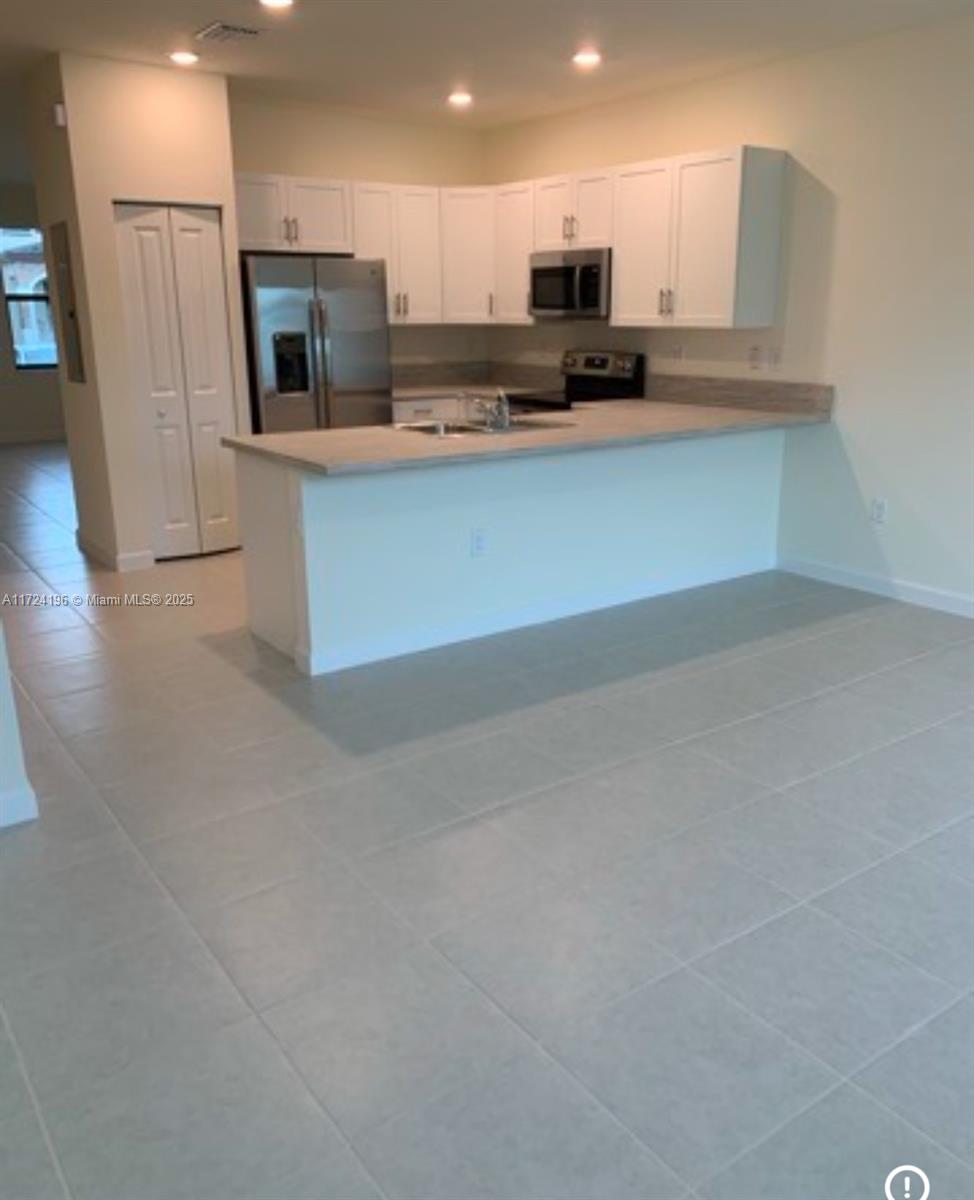 3416 West 111th Place Hialeah, FL 33018 - Photo 3 of 5 a kitchen with stainless steel appliances a refrigerator and a stove top oven