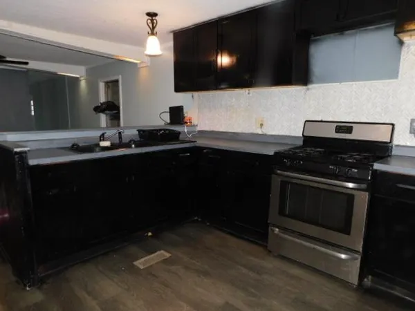 a kitchen with sink a microwave a stove and cabinets