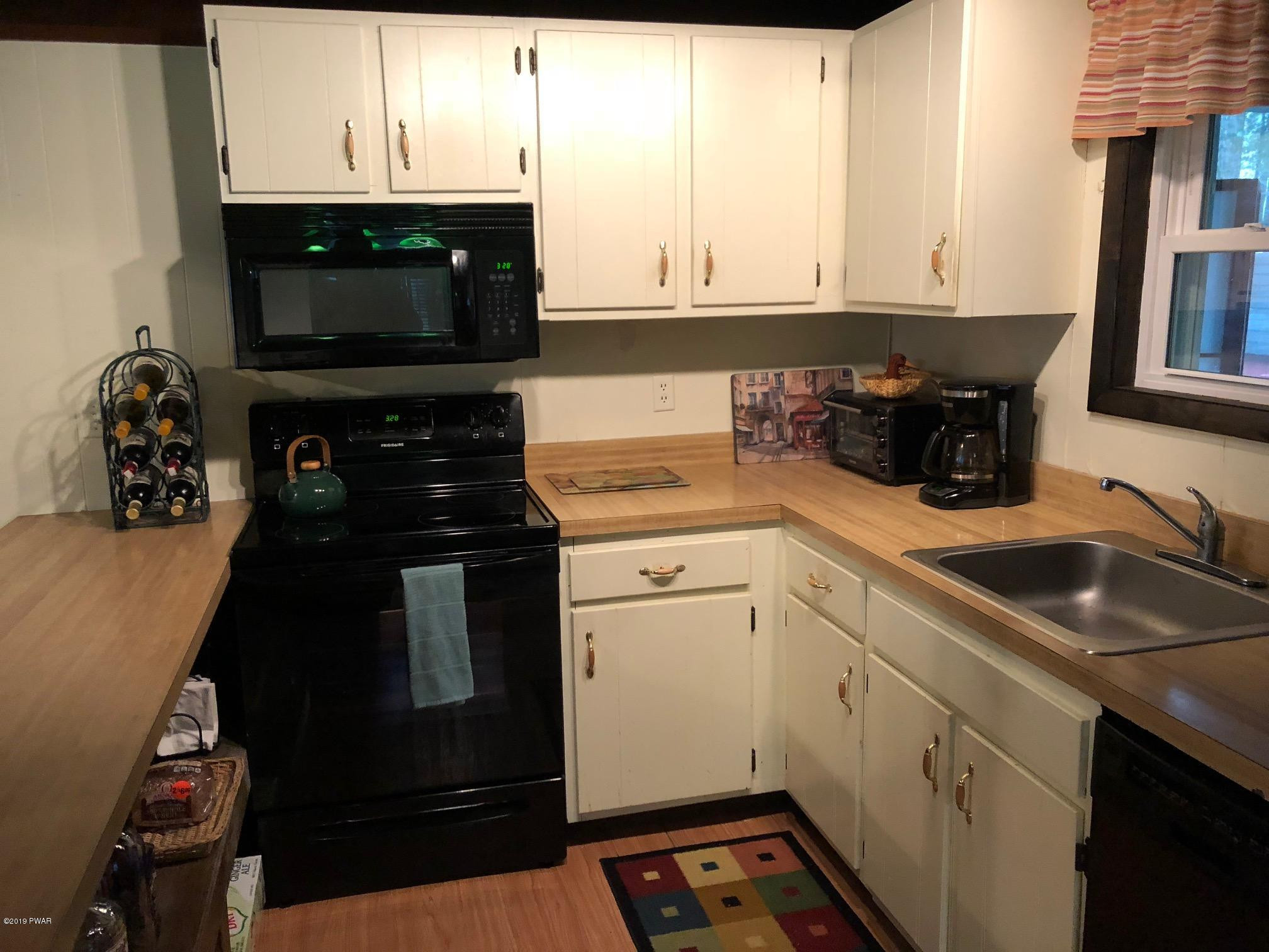 176 Heather Hill Road Dingmans Ferry, PA 18328 - Photo 11 of 32 a kitchen with a sink and cabinets