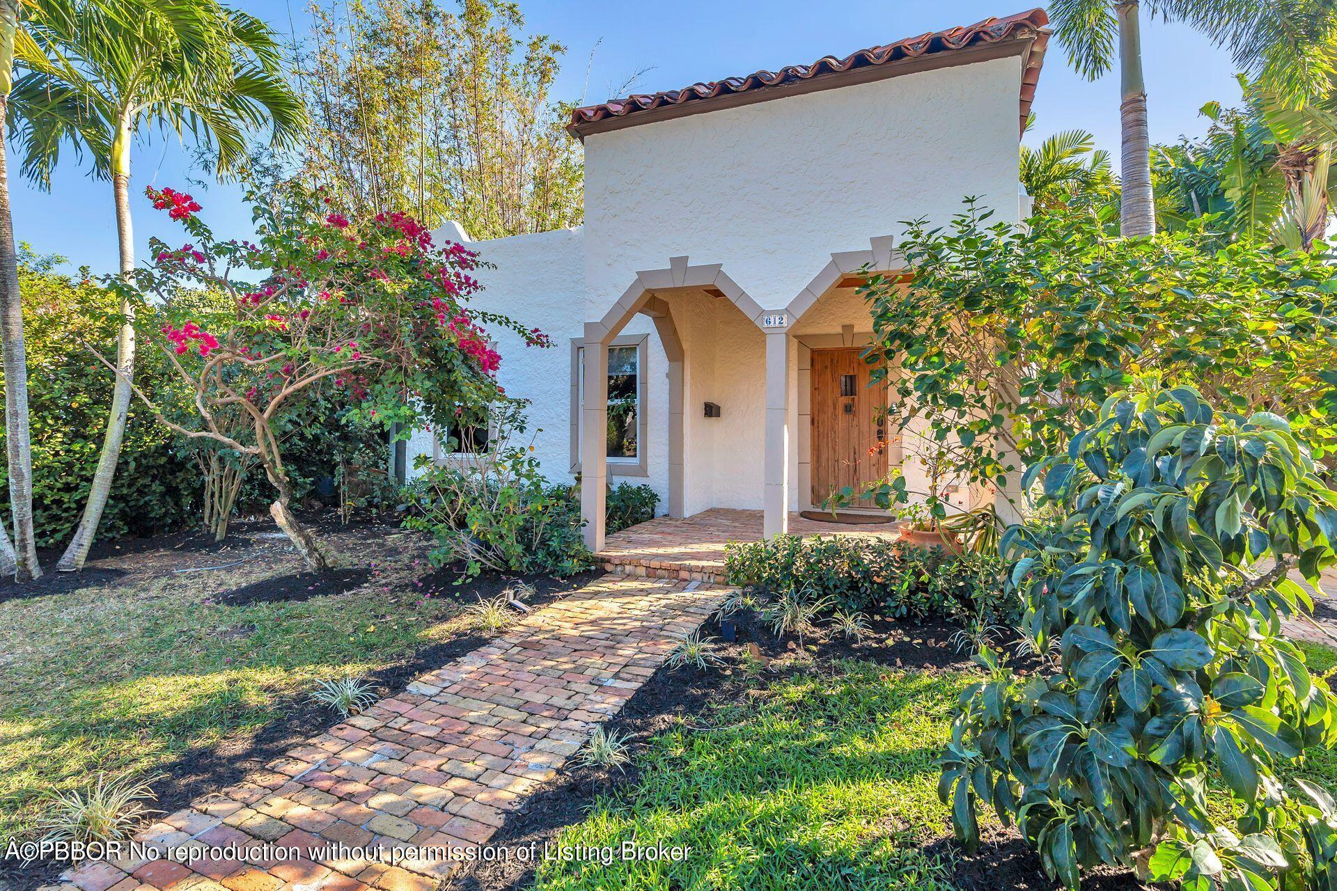 612 Upland Road West Palm Beach, FL 33401 - Photo 1 of 24 a front view of a house with a yard and potted plants