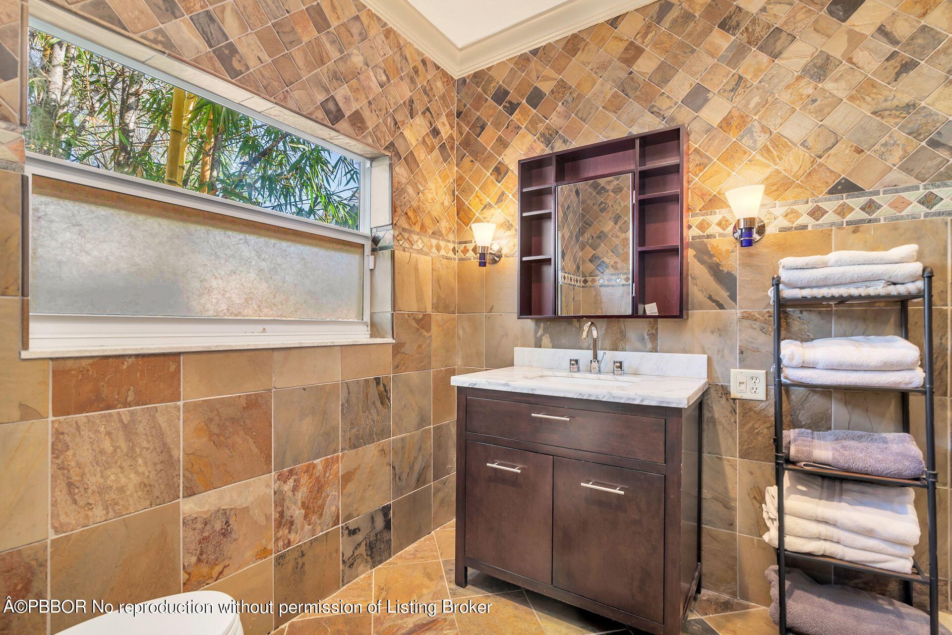 612 Upland Road West Palm Beach, FL 33401 - Photo 11 of 24 a bathroom with a sink a mirror and a shower