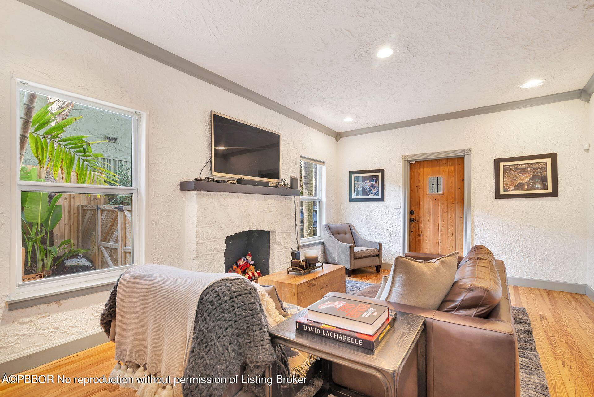 612 Upland Road West Palm Beach, FL 33401 - Photo 5 of 24 a living room with furniture a fireplace and a flat screen tv