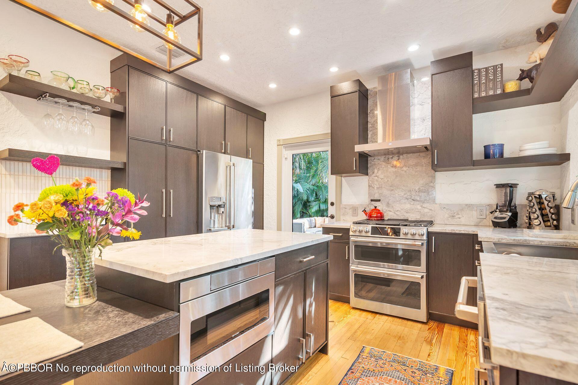 612 Upland Road West Palm Beach, FL 33401 - Photo 7 of 24 a kitchen that has a lot of cabinets a sink and a stove in it