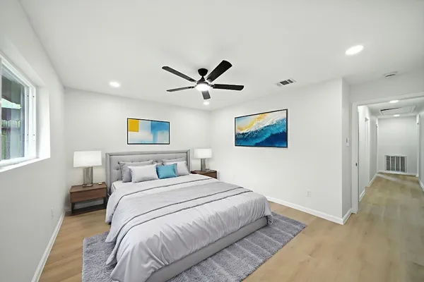 a bedroom with a large bed and a ceiling fan