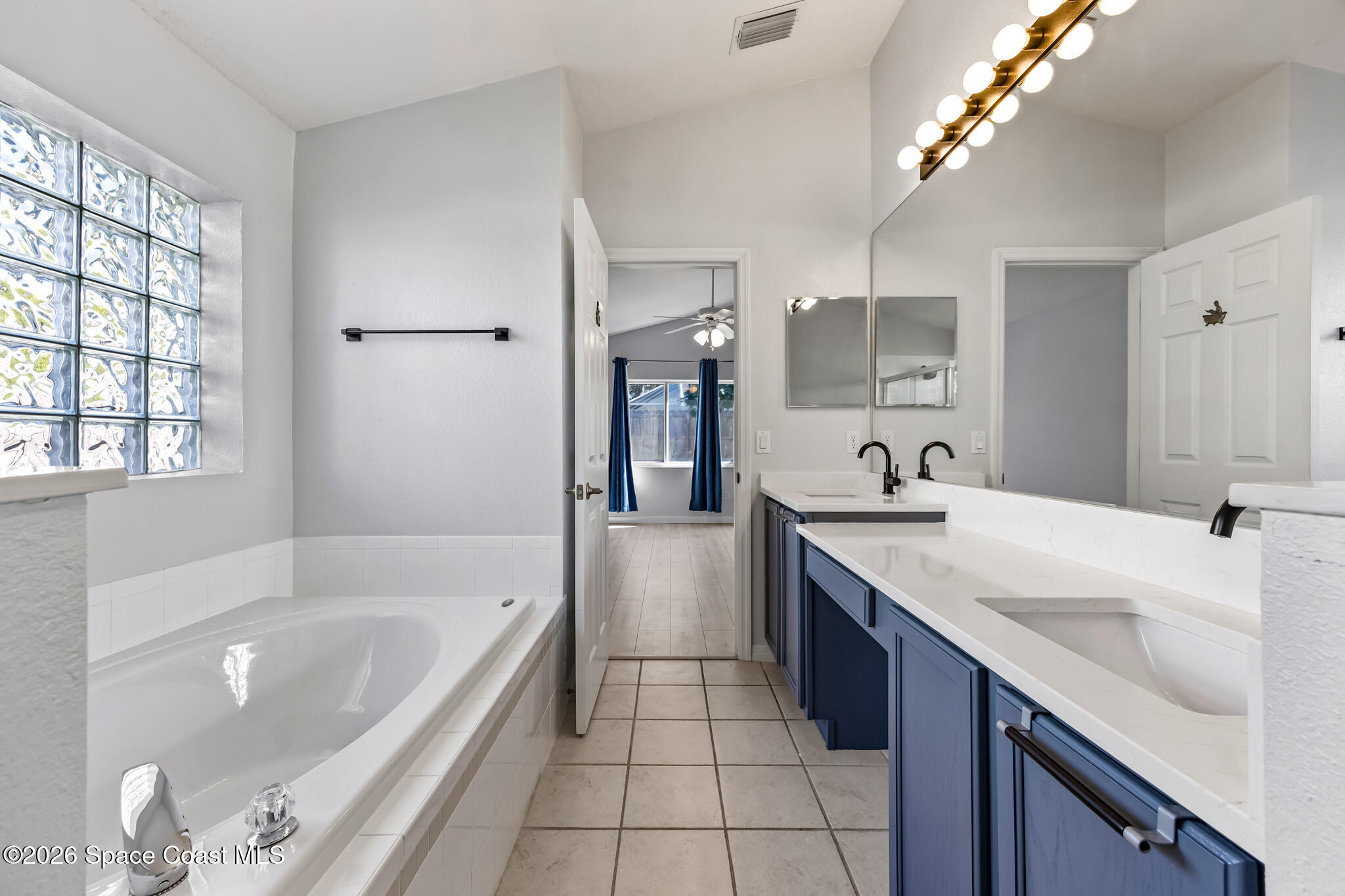 1915 Worchester Way Merritt Island, FL 32953 - Photo 13 of 27 a spacious bathroom with a granite countertop tub a sink and a large mirror