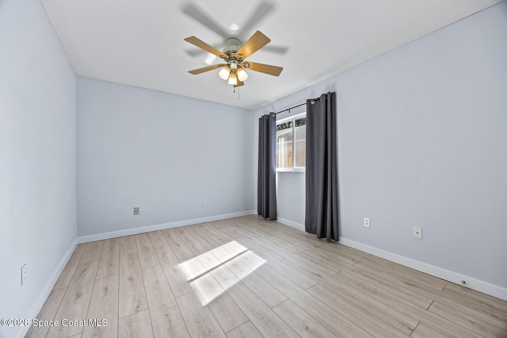 1915 Worchester Way Merritt Island, FL 32953 - Photo 18 of 27 an empty room with wooden floor chandelier fan and windows