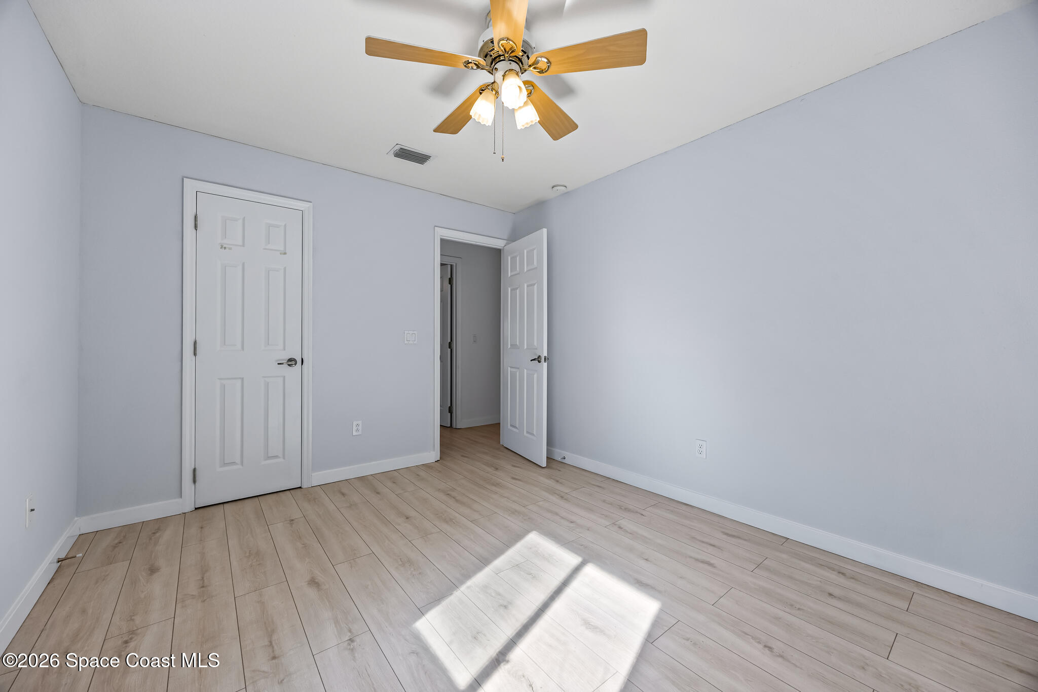 1915 Worchester Way Merritt Island, FL 32953 - Photo 19 of 27 wooden floor in an empty room with a chandelier fan