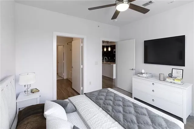 a spacious bedroom with a bed and a flat screen tv