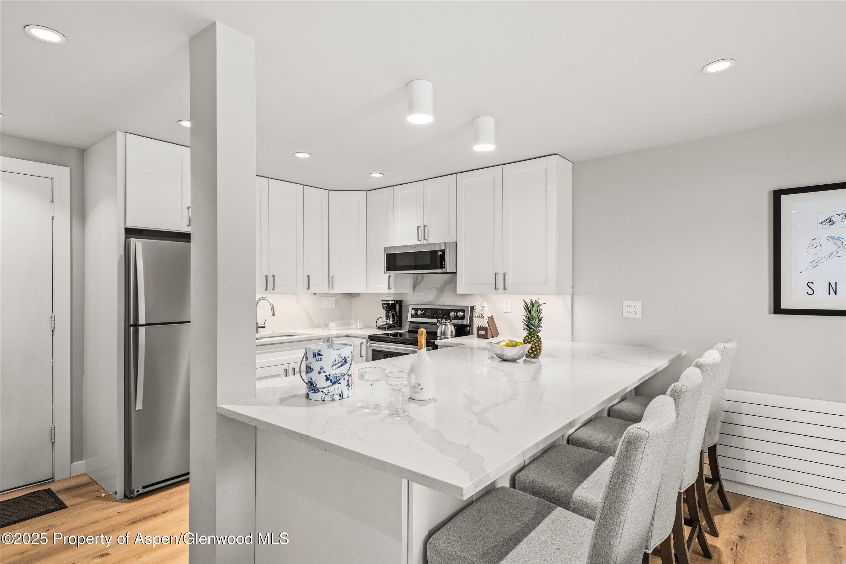 150 Carriage Way, Unit 3 Snowmass Village, CO 81615 - Photo 6 of 12 a kitchen with kitchen island a sink appliances and cabinets