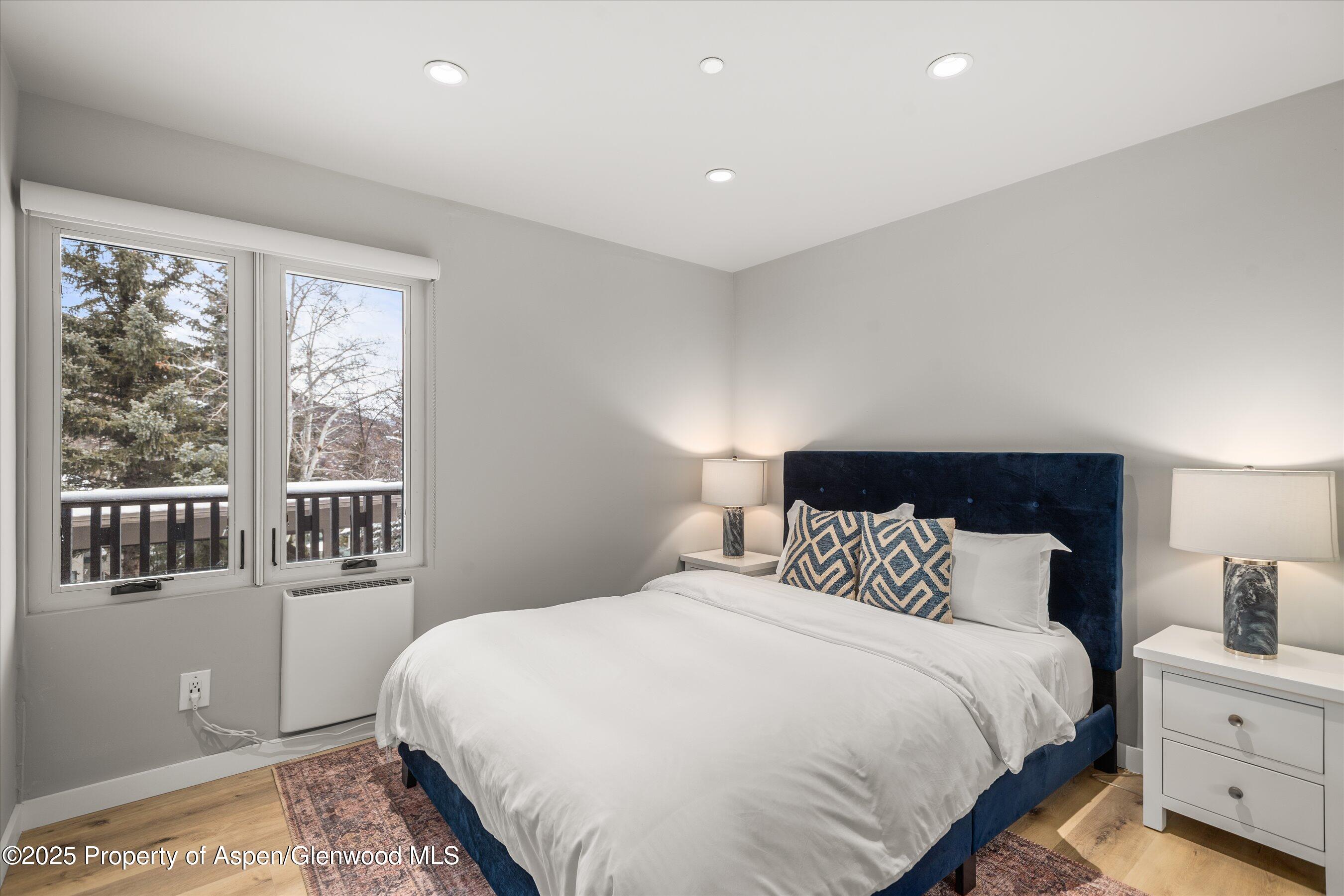 150 Carriage Way, Unit 3 Snowmass Village, CO 81615 - Photo 7 of 12 a bedroom with a large bed and a large window