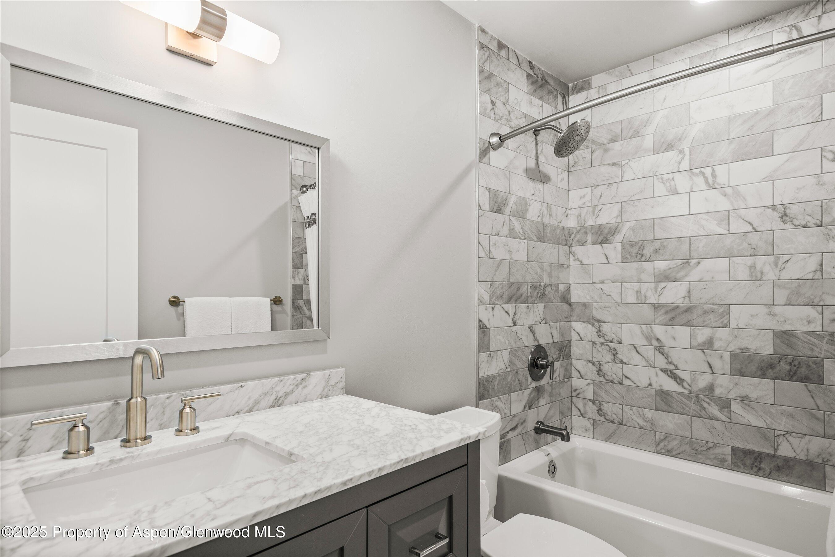 150 Carriage Way, Unit 3 Snowmass Village, CO 81615 - Photo 8 of 12 a bathroom with a granite countertop sink a toilet and shower
