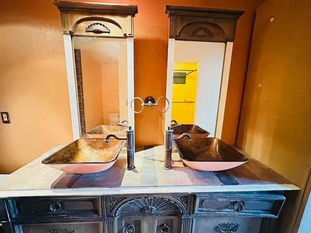 a view of a backyard space with a fountain and a large tree