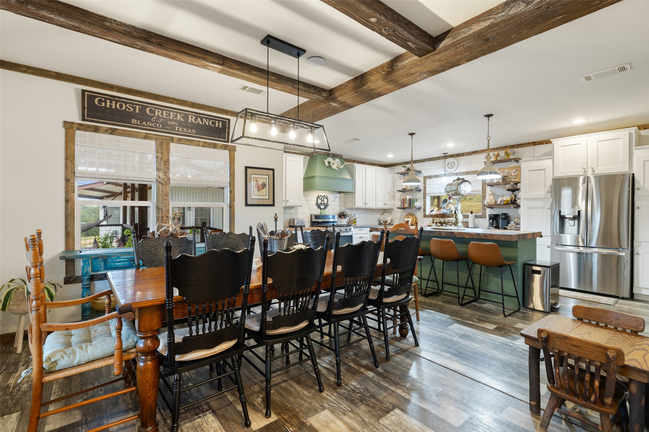 830 Ulrich Road Johnson City, TX 78636 - Photo 18 of 40 Exposed wood beams add rustic charm to this bright, open-concept dining and kitchen space.