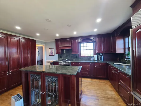 a kitchen with kitchen island granite countertop wooden cabinets a counter top space and stainless steel appliances