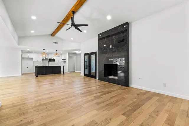 an empty room with kitchen and a fireplace