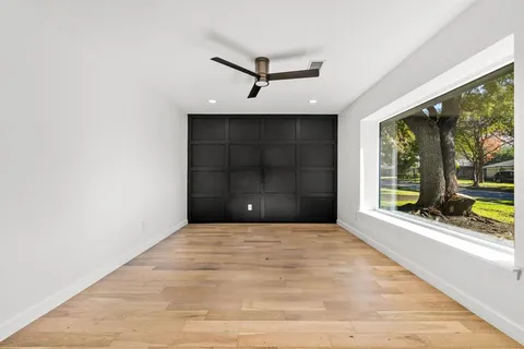 a view of an empty room with a window and a ceiling fan