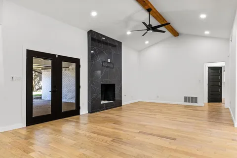 a view of an empty room with glass door and a bathroom