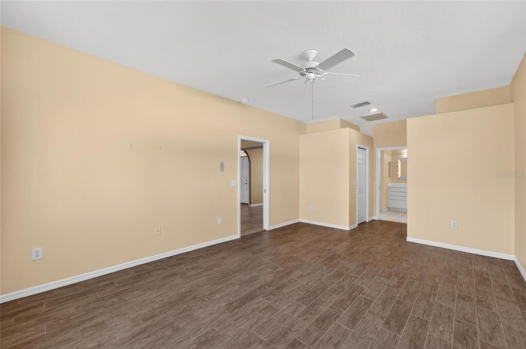 1615 Oracle Drive Ruskin, FL 33573 - Photo 38 of 87 a view of an empty room with wooden floor and a ceiling fan