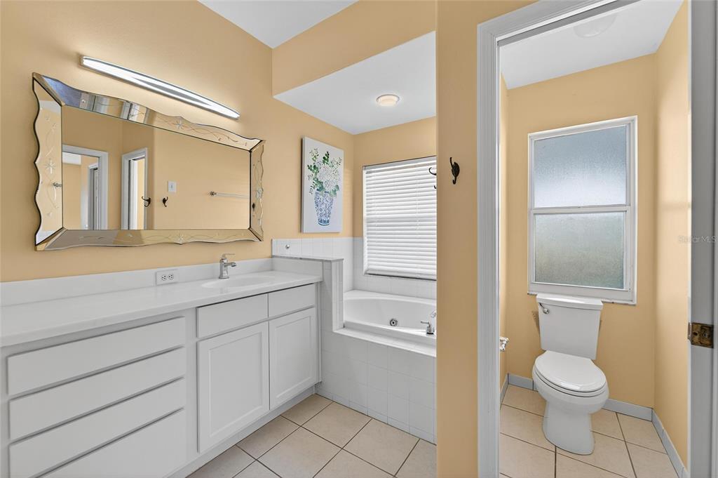 1615 Oracle Drive Ruskin, FL 33573 - Photo 44 of 87 a bathroom with a toilet a sink a mirror and a shower