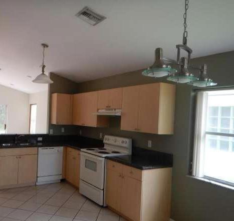 11217 Harbour Springs Circle Boca Raton, FL 33428 - Photo 12 of 12 a kitchen with granite countertop white cabinets and black appliances