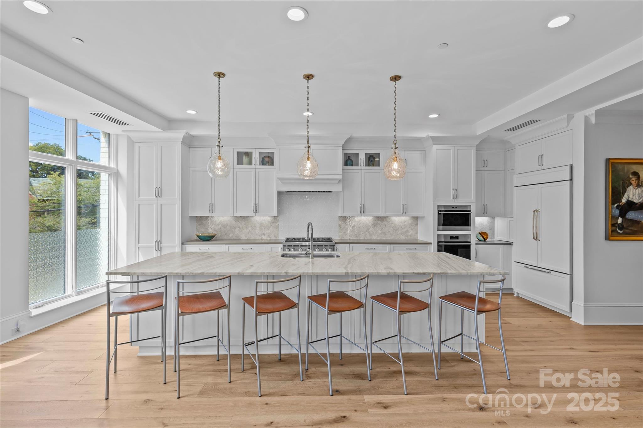 1500 Queens Road, Unit 104 Charlotte, NC 28207 - Photo 7 of 43 a large kitchen with kitchen island a dining table and chairs