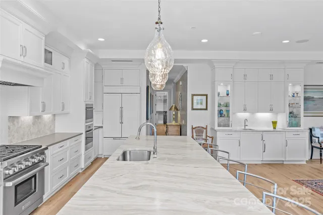 a large kitchen with stainless steel appliances granite countertop a lot of counter space and wooden floor