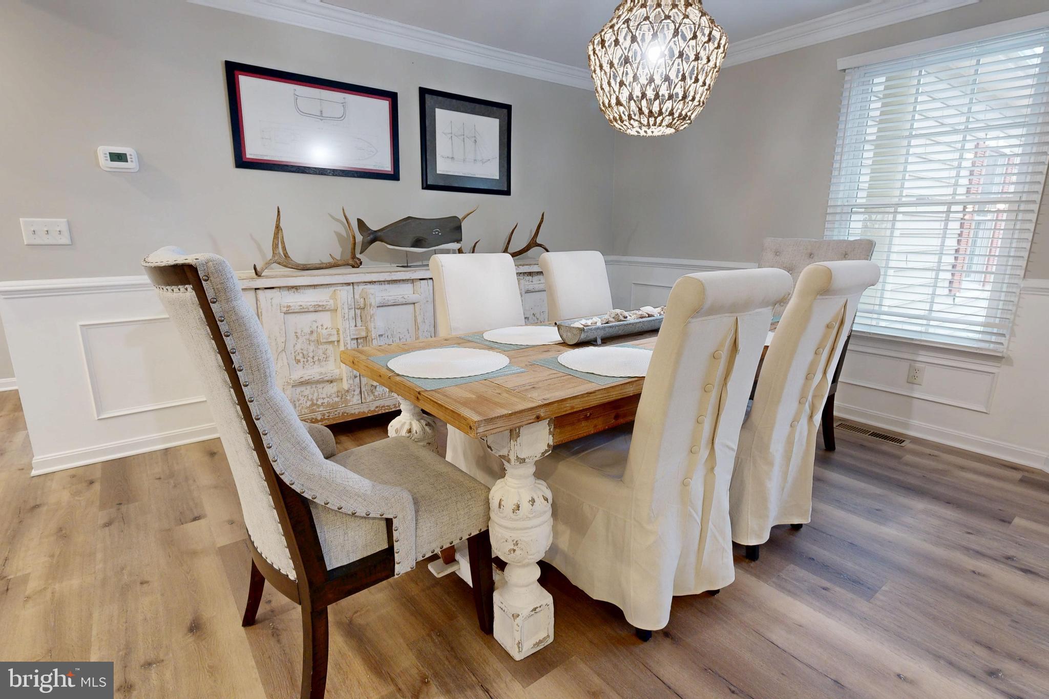 28715 Jacks Field Road Wye Mills, MD 21679 - Photo 11 of 27 a dining room with wooden floor a chandelier a wooden table and chairs