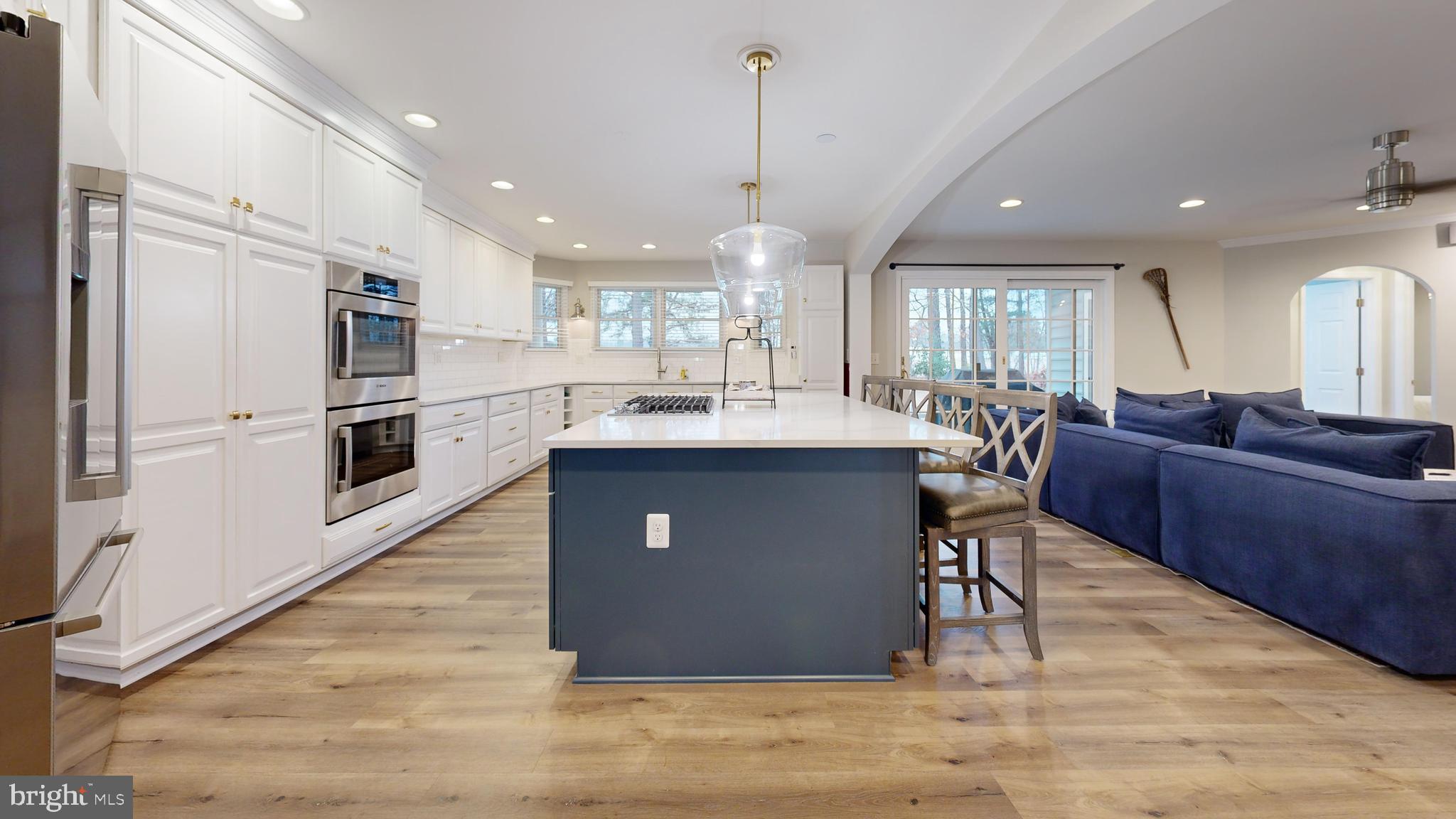 28715 Jacks Field Road Wye Mills, MD 21679 - Photo 13 of 27 a kitchen with stainless steel appliances kitchen island granite countertop a refrigerator a stove a sink a dining table and chairs with wooden floor