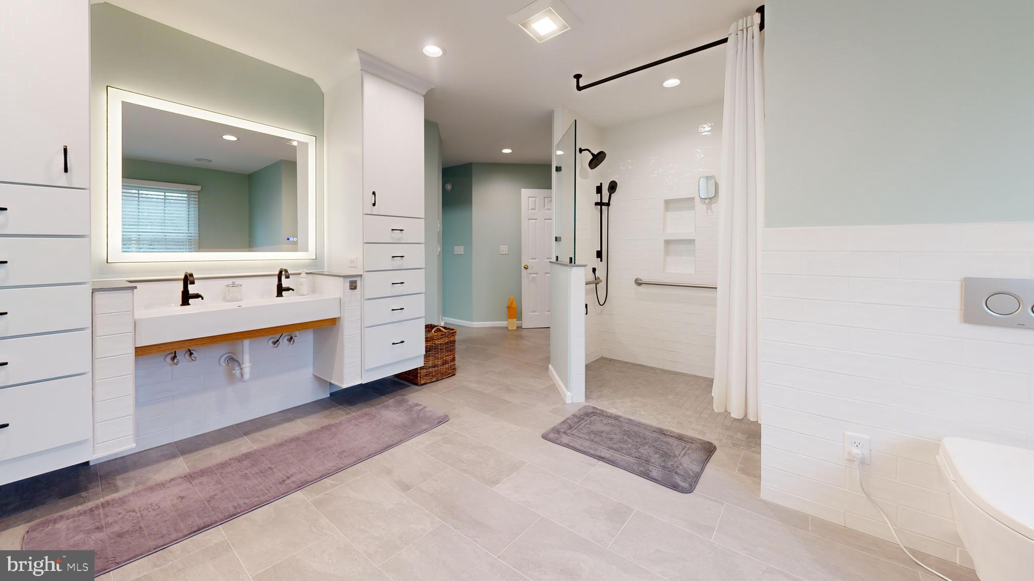 28715 Jacks Field Road Wye Mills, MD 21679 - Photo 15 of 27 a bathroom with a double vanity sink a large mirror and shower