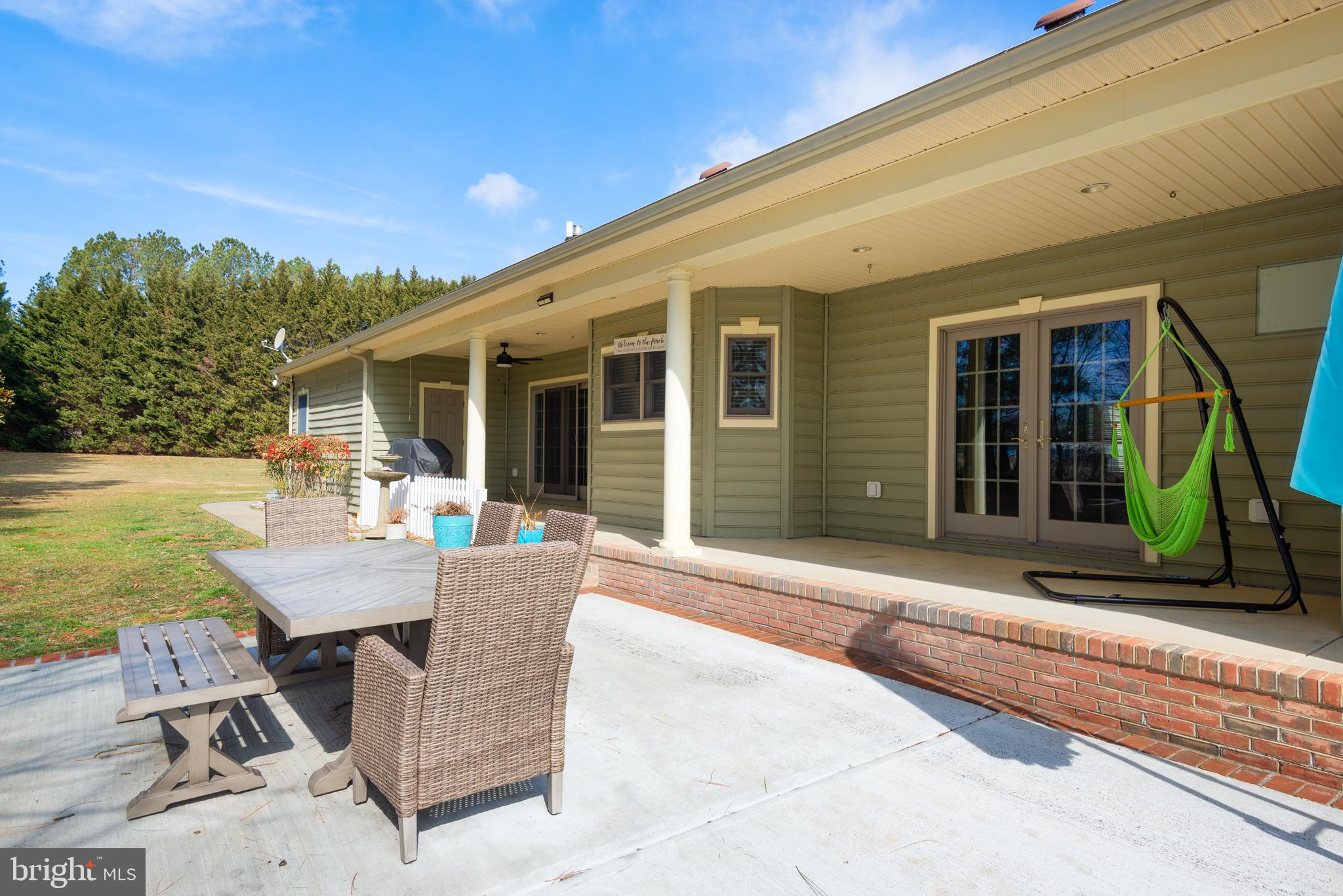 28715 Jacks Field Road Wye Mills, MD 21679 - Photo 3 of 27 a patio with a table and chairs and potted plants