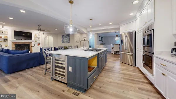 a large kitchen with stainless steel appliances kitchen island granite countertop a stove a refrigerator a oven and a sink with large countertops