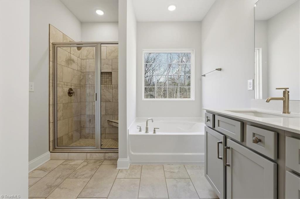 519 Valentine Court Graham, NC 27253 - Photo 24 of 42 primary bath with tiled shower and garden tub