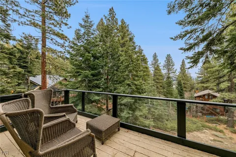 a view of a balcony with chairs and wooden fence
