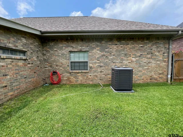 a view of backyard with potted plants and wooden fence