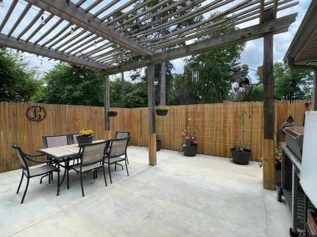 a view of a patio with table and chairs and floor to ceiling window with wooden floor