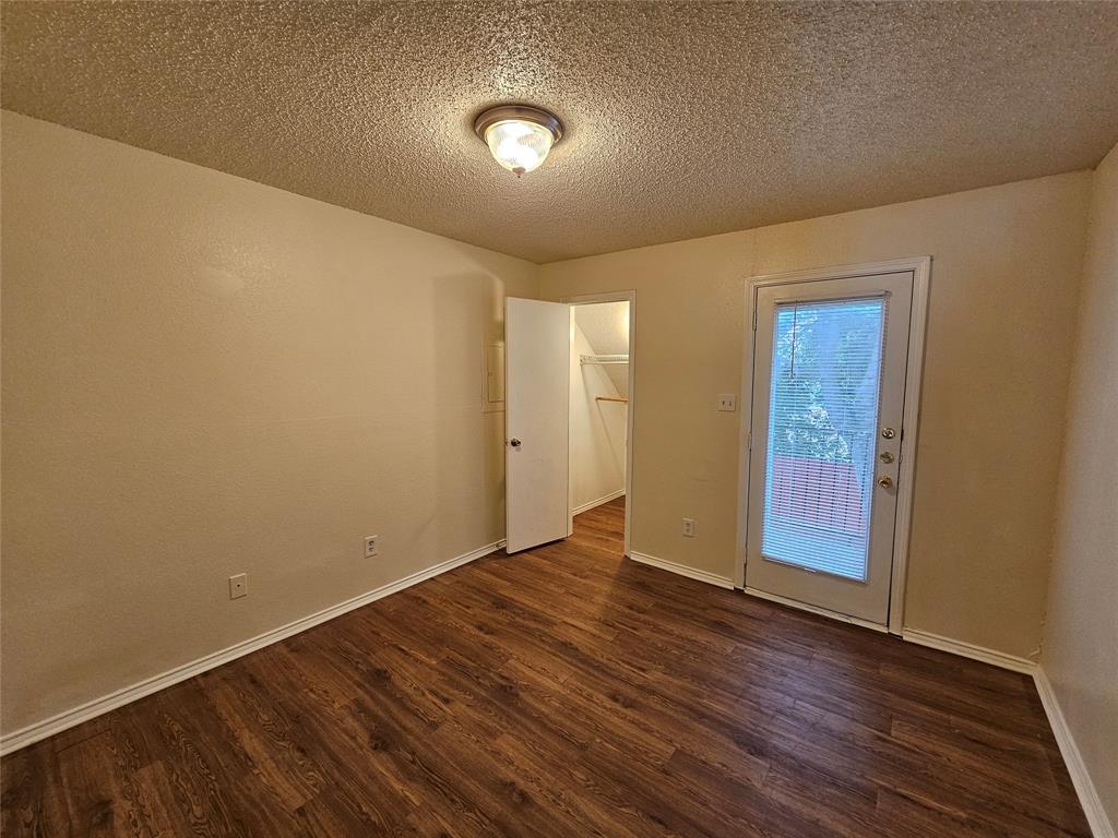 9823 Walnut Street, Unit 208 Dallas, TX 75243 - Photo 12 of 16 an empty room with wooden floor and windows