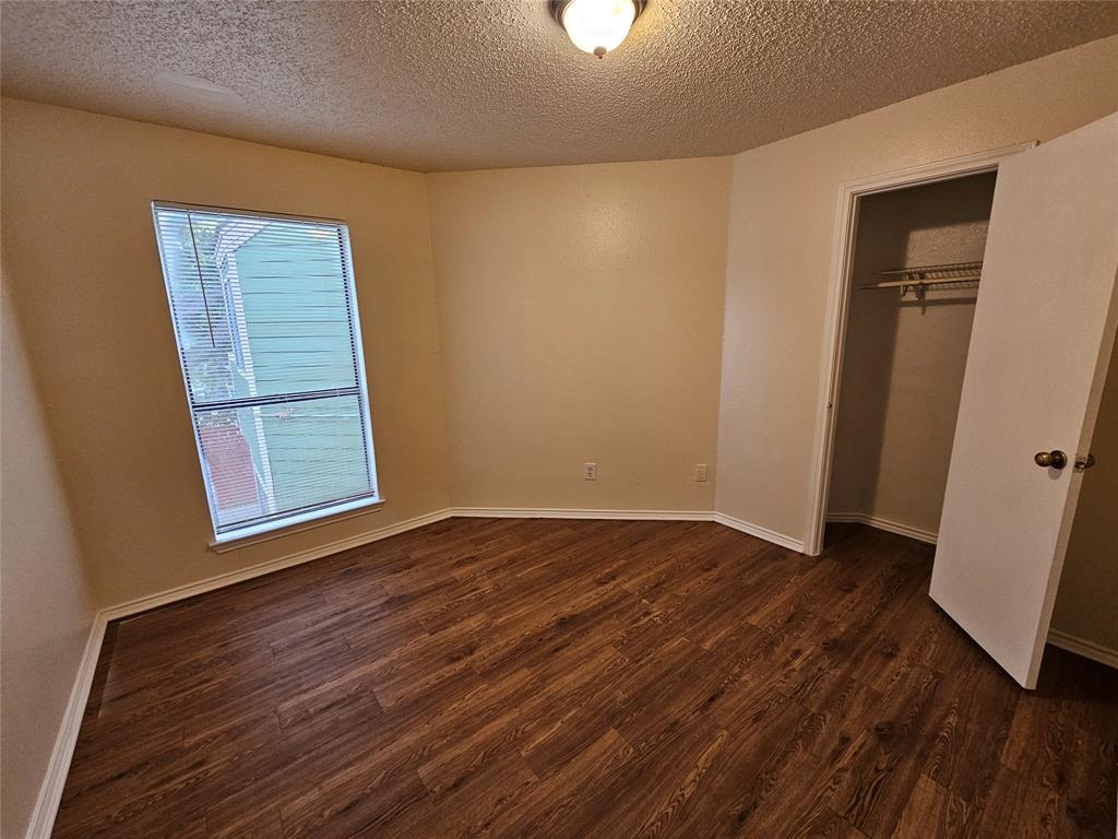 9823 Walnut Street, Unit 208 Dallas, TX 75243 - Photo 10 of 16 a view of an empty room with wooden floor and a window